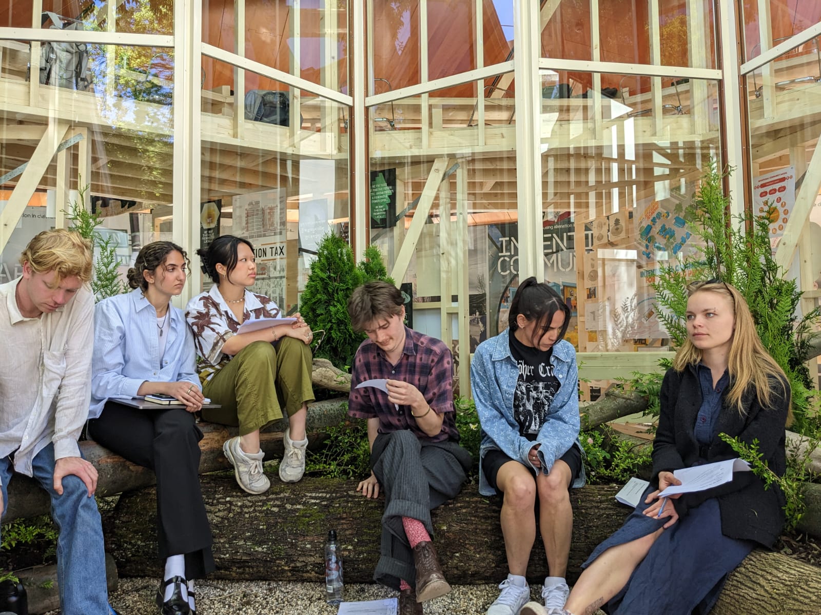 Group of students reading on the planters, reading and working.